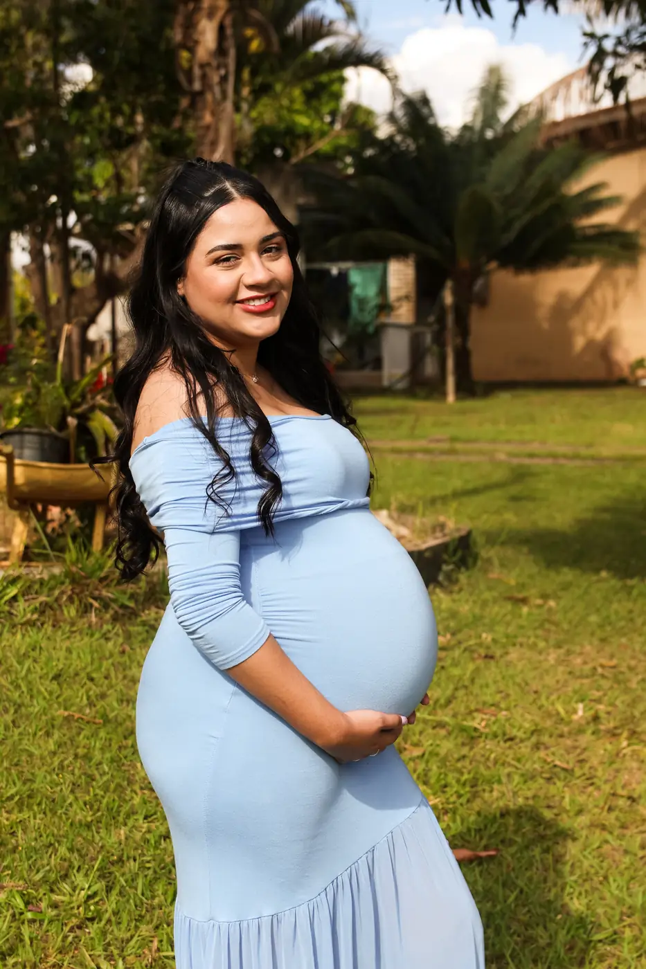 Gestante de vestido azul num jardim