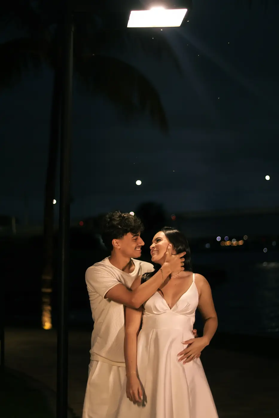 Casal abraçado à noite à beira do lago